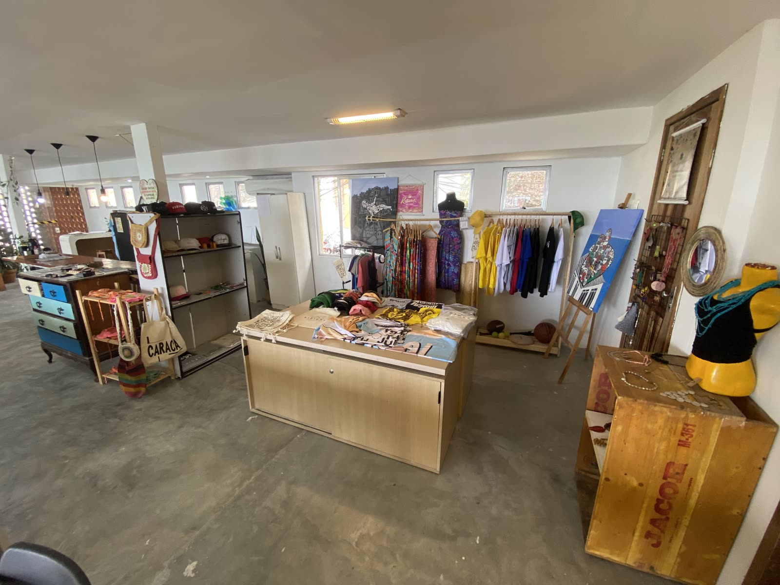 Loja Terra Fértil — interior com araras de roupas e artesanato